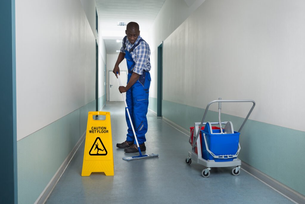 Day Porter Young African Male Janitor Cleaning Floor In Corridor
